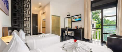 A hotel room with two beds, a desk, a TV, and a balcony with a view.