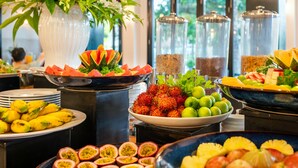 Un bufé con diversas frutas y verduras, entre ellas plátanos, maracuyá y sandía.