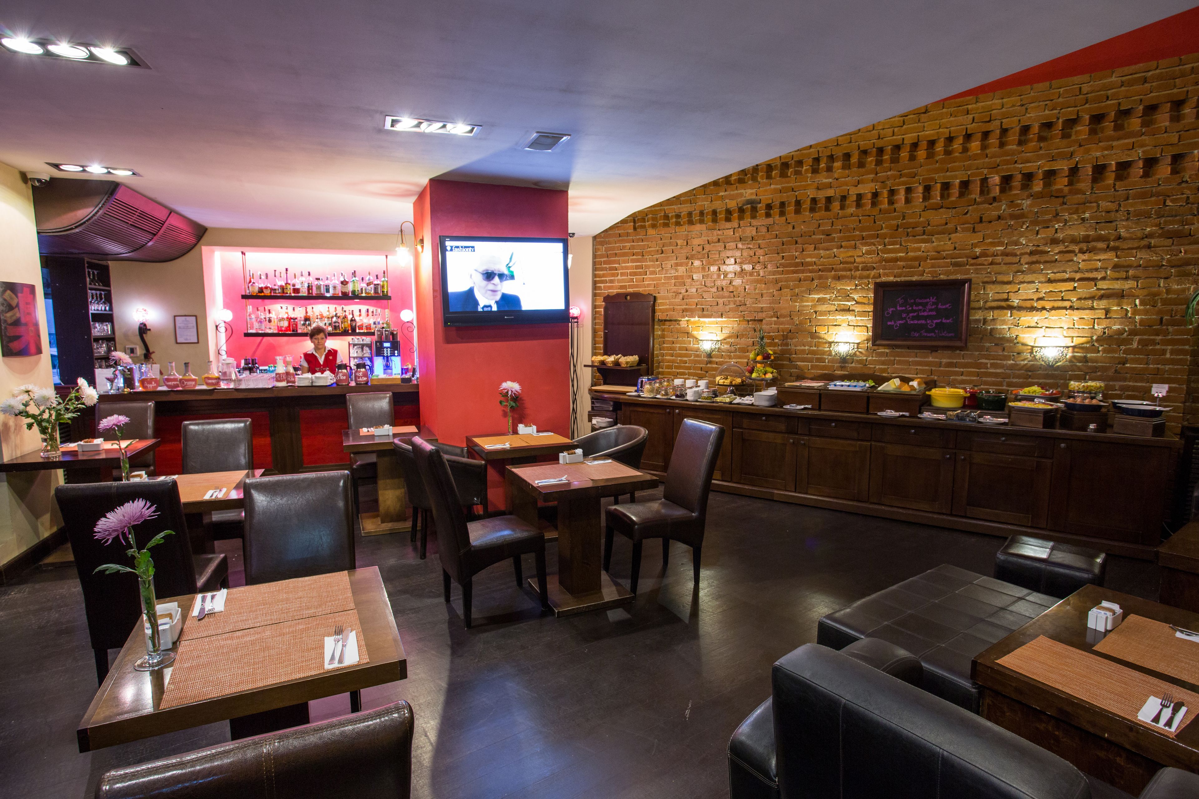 Un restaurante con barra, mesas y sillas.