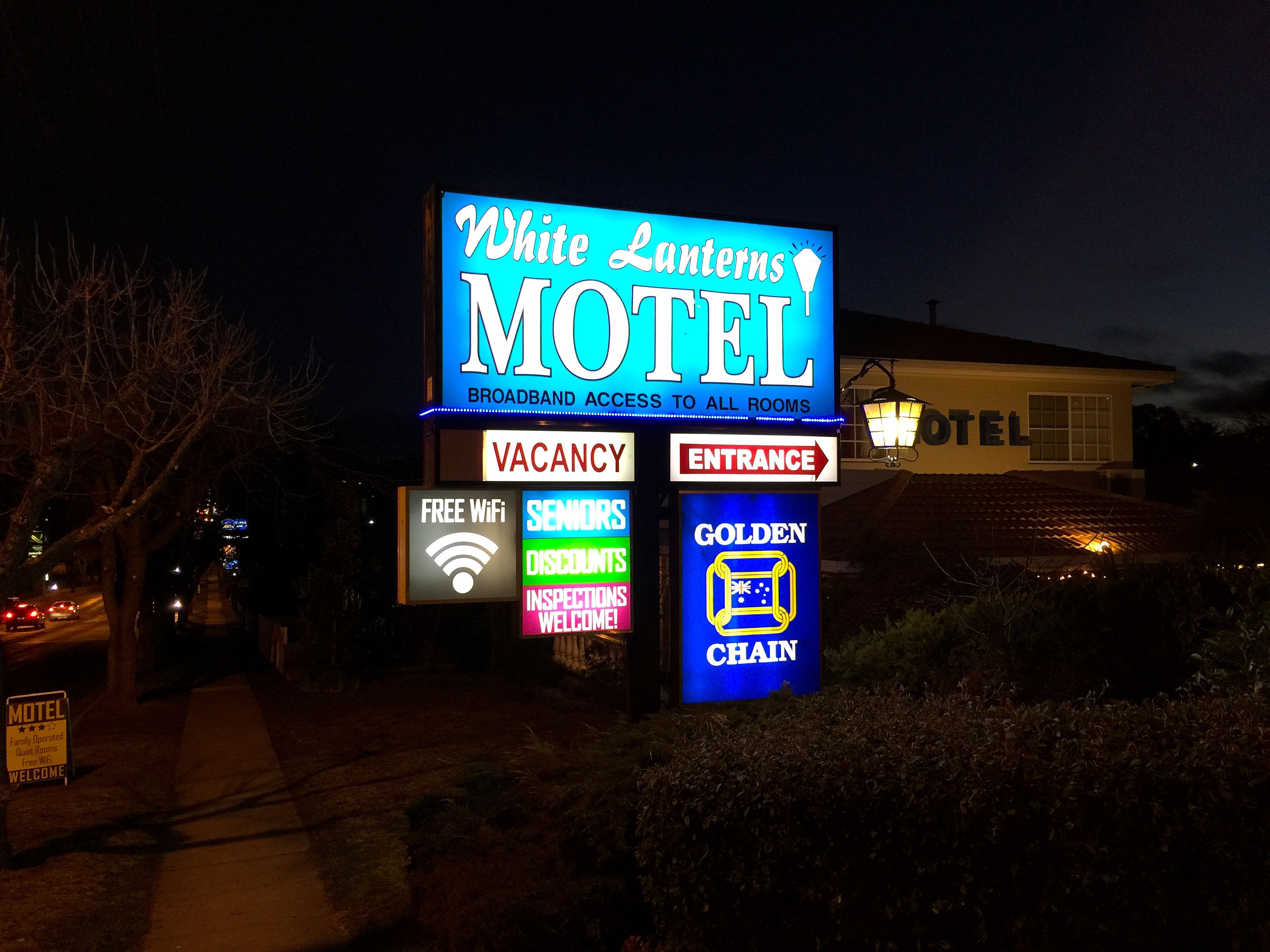 A motel sign with "White Lanterns Motel" and "Free WiFi" visible.