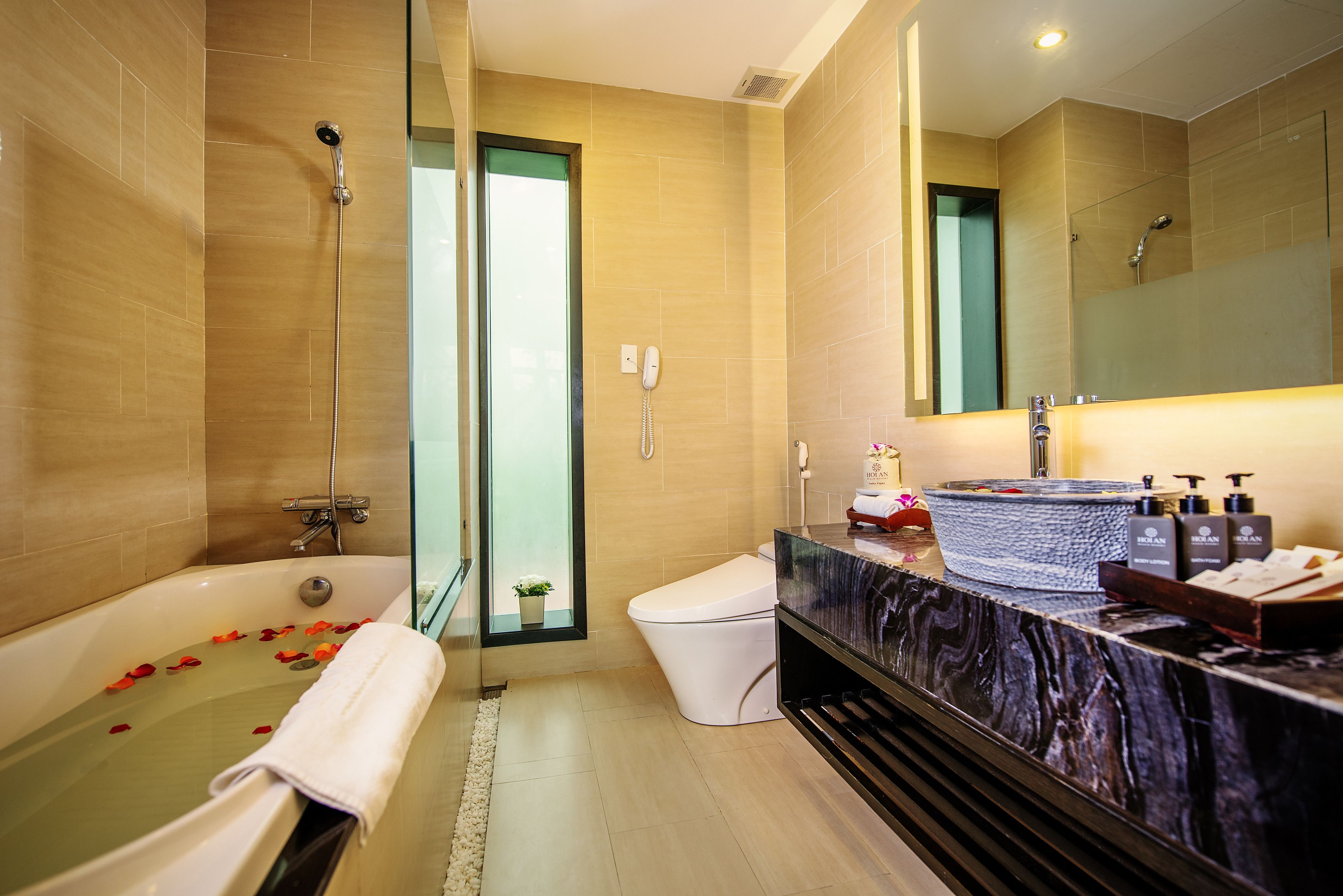 A modern bathroom with a bathtub, toilet, and shower.