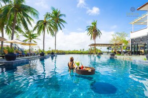 A swimming pool with lounge chairs and palm trees. - Hoi An Beach Resort (Da Nang)