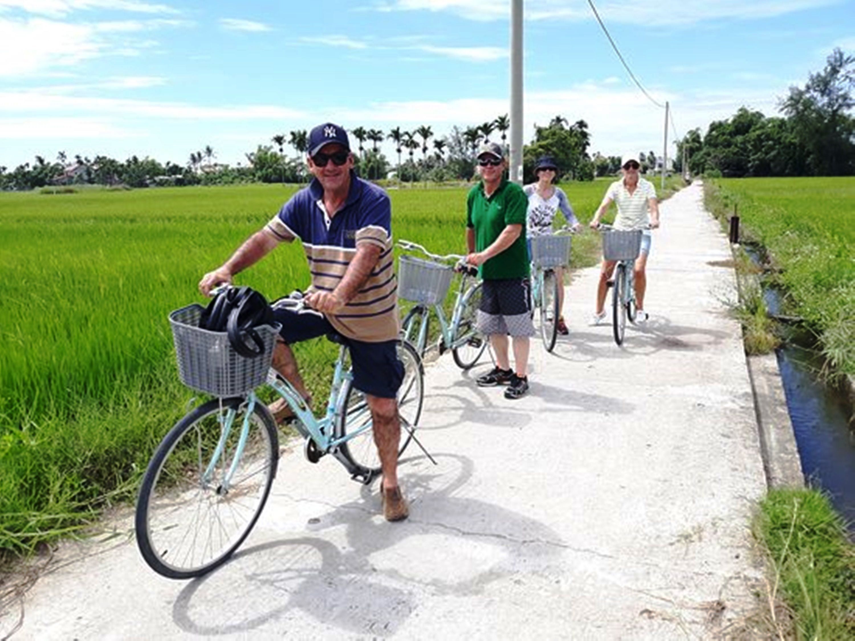 Un sentier pour les cyclistes, un canal et des champs verdoyants.