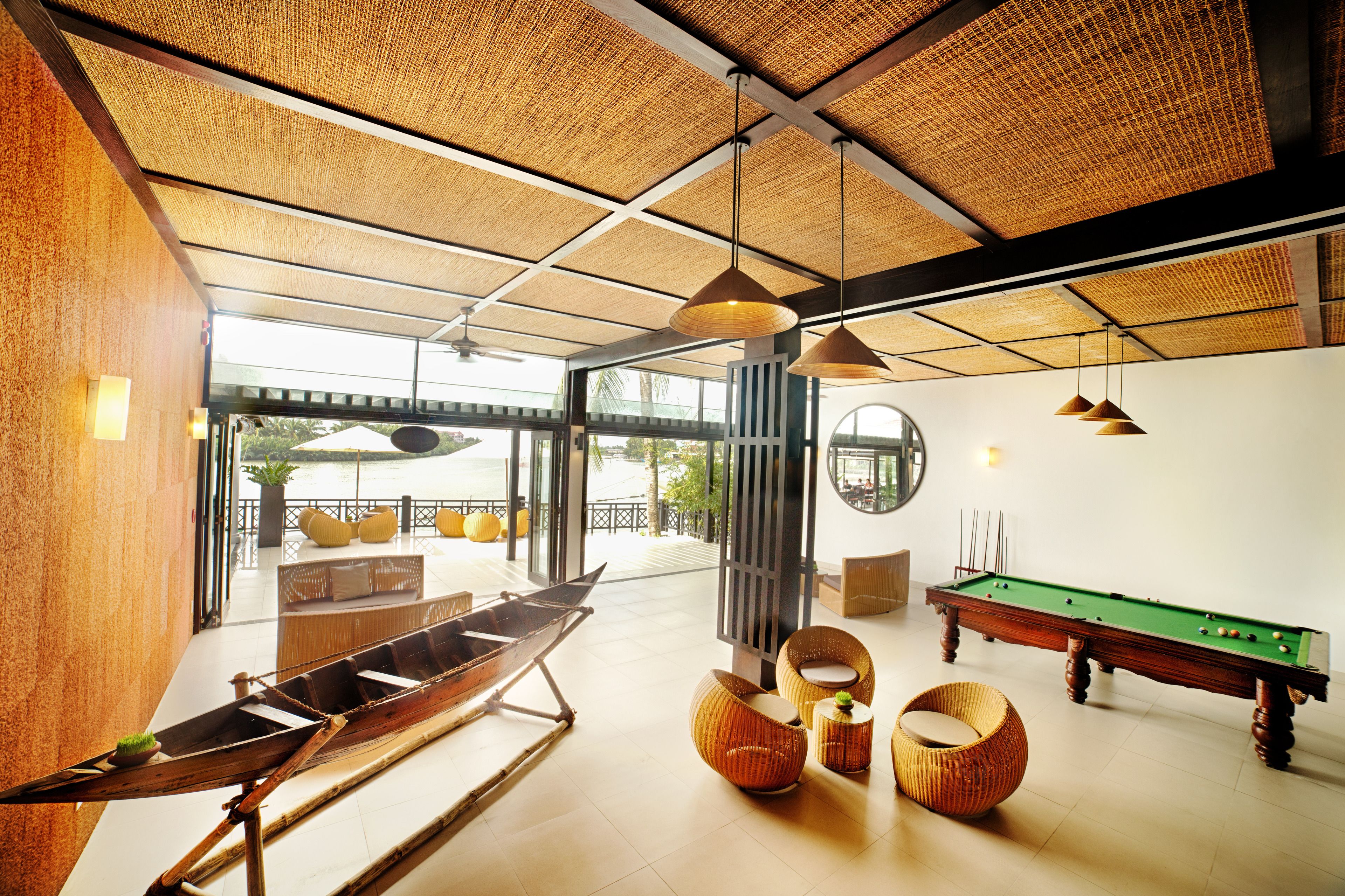 Um espaço amplo e interno com mesa de bilhar, assentos confortáveis e uma grande janela com vista para o exterior.