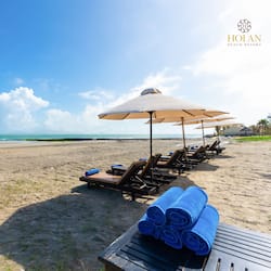 Aan een privéstrand, wit zand, ligstoelen, parasols