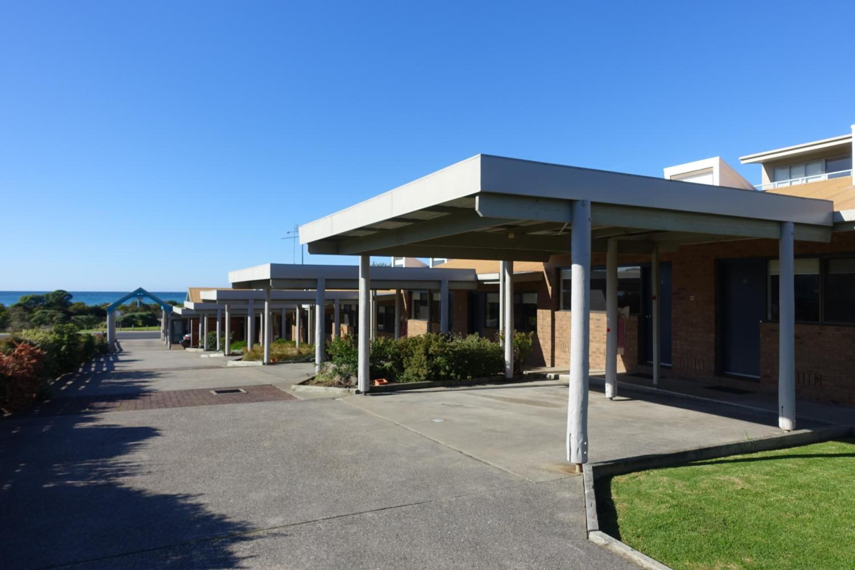 A modern building with covered walkways and a clear view of the ocean.