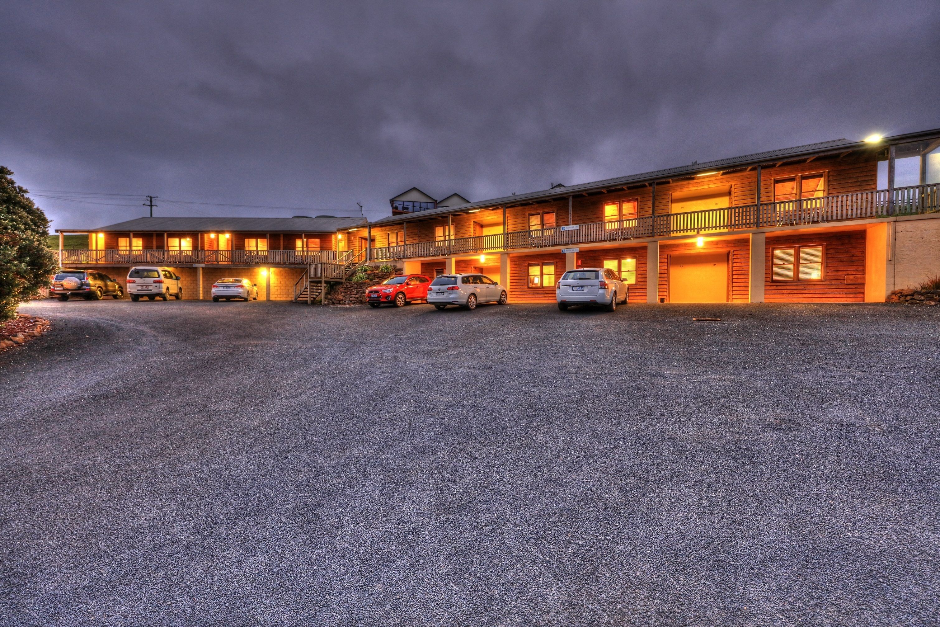 Un motel à plusieurs étages, doté d’un parking couvert et d’une allée en gravier.