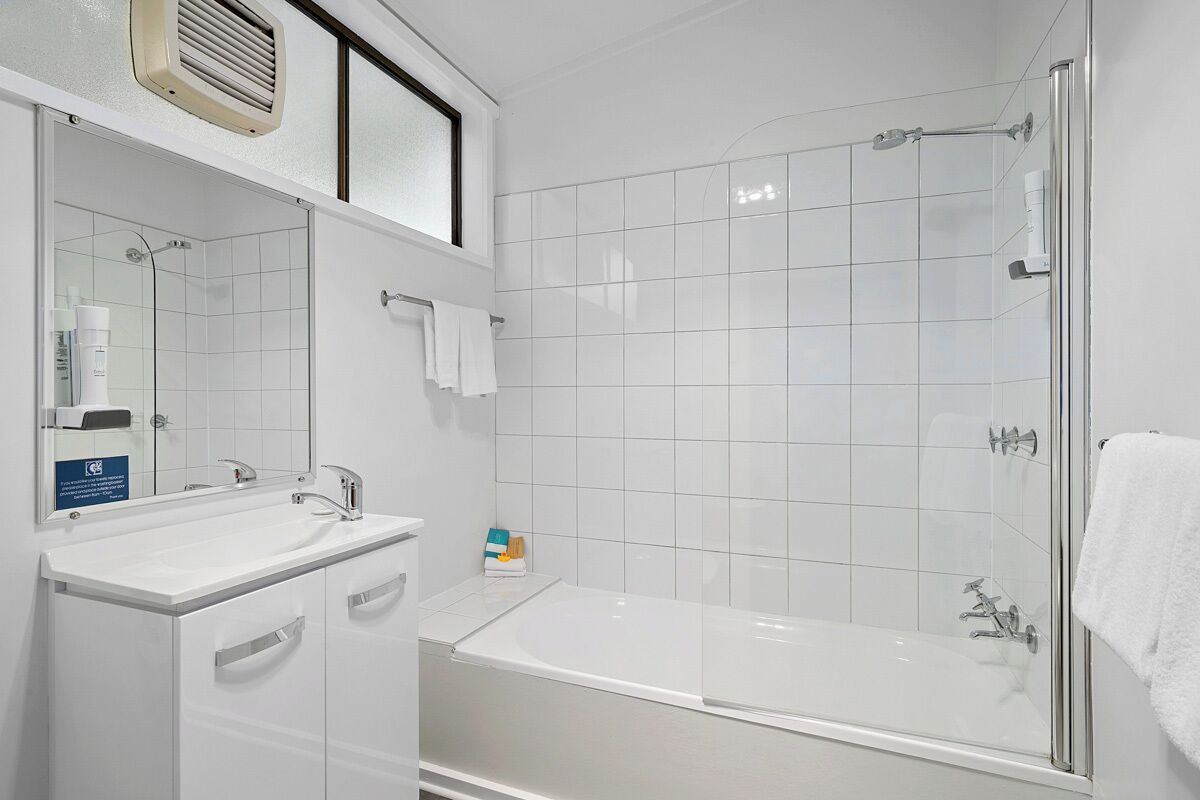 A modern bathroom with a bathtub, a shower, and a vanity with a mirror.
