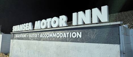 Indicador del Swansea Motor Inn, que mostra que és un allotjament econòmic i a peu de platja.