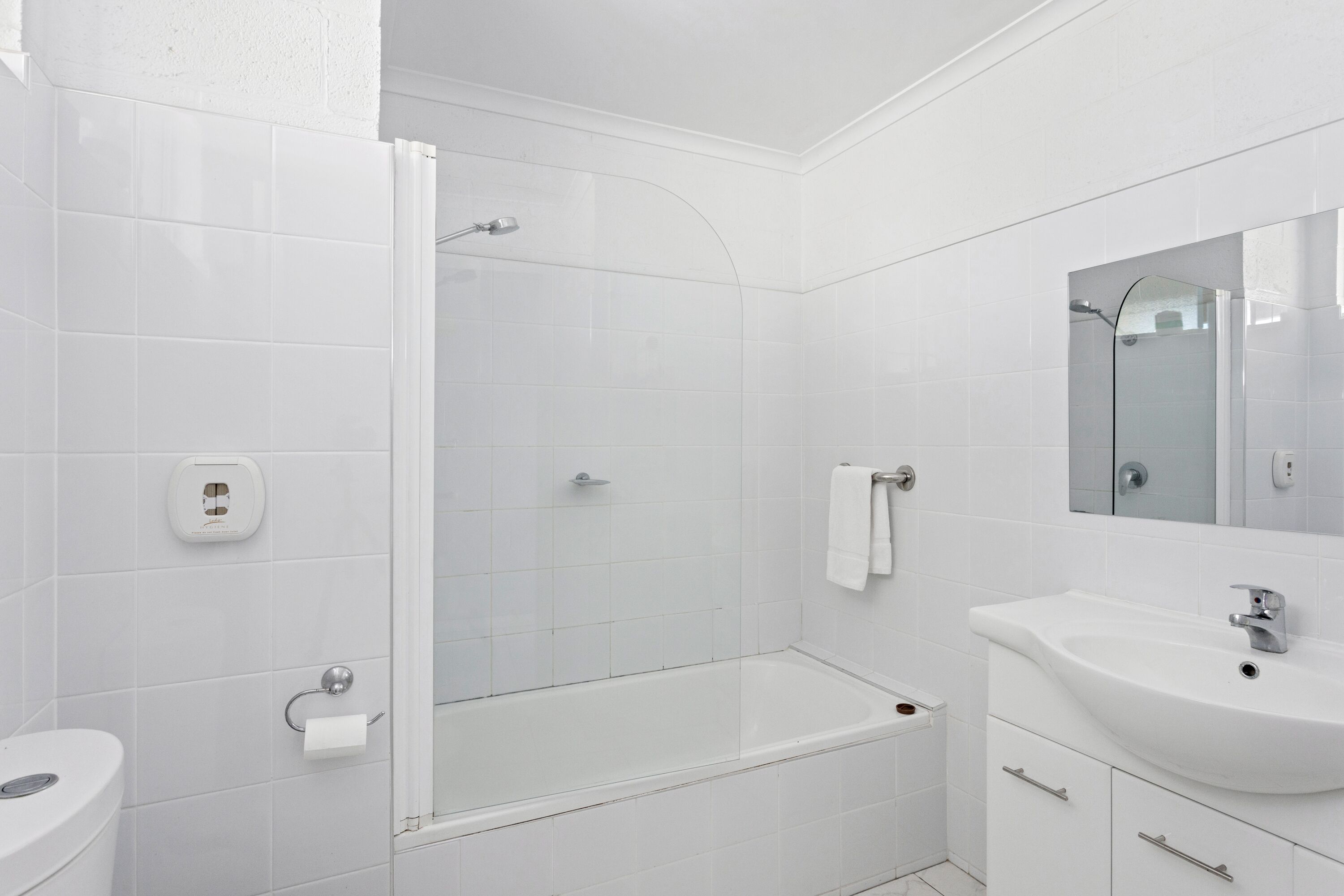 Un baño moderno con bañera, lavabo y espejo.