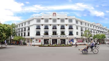 A large, white building with the sign "HOTEL SAIGON MORIN" at the entrance, featuring multiple windows and balconies.