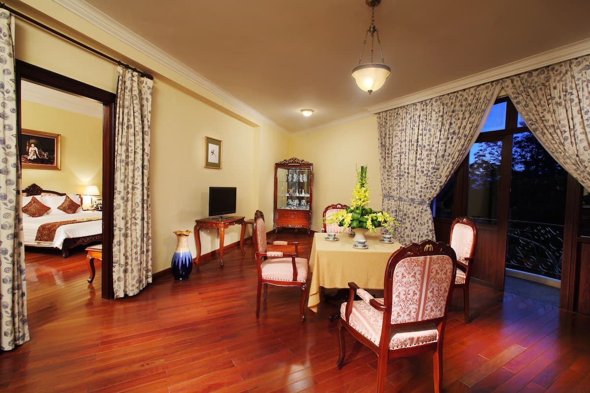 A dining area with a table, chairs, and a vase of flowers.