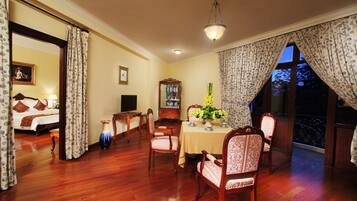A dining area with a table, chairs, and a vase of flowers.