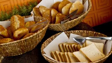Three wicker baskets containing bread and a knife.
