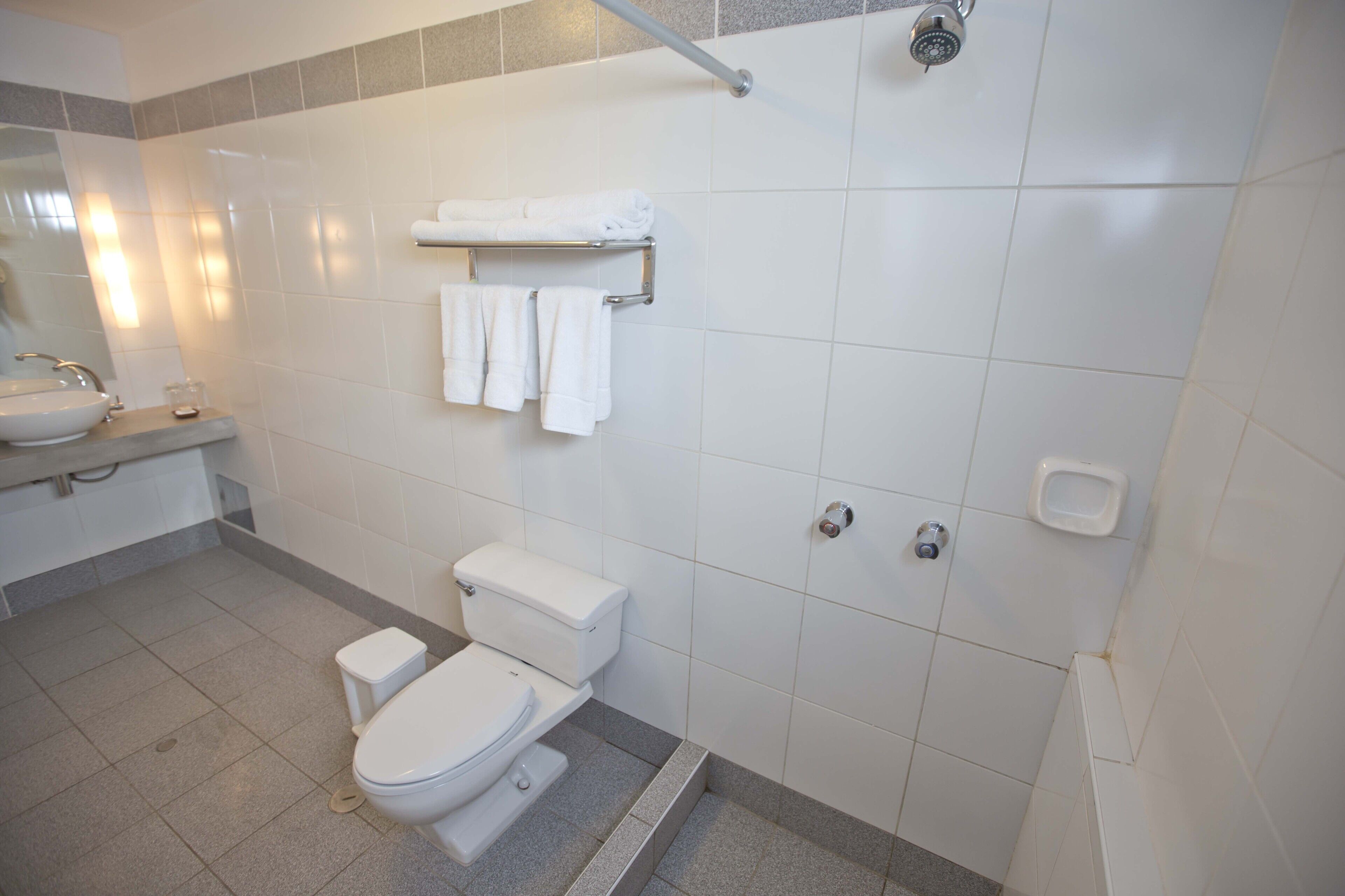 A modern bathroom with a toilet, sink, and shower.