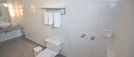 A modern bathroom with a toilet, sink, and shower.