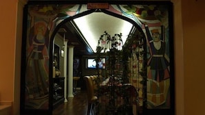 A hallway with a stained glass archway leading to a room with a television. - Boutique Palace Hotel Baku (Baku)