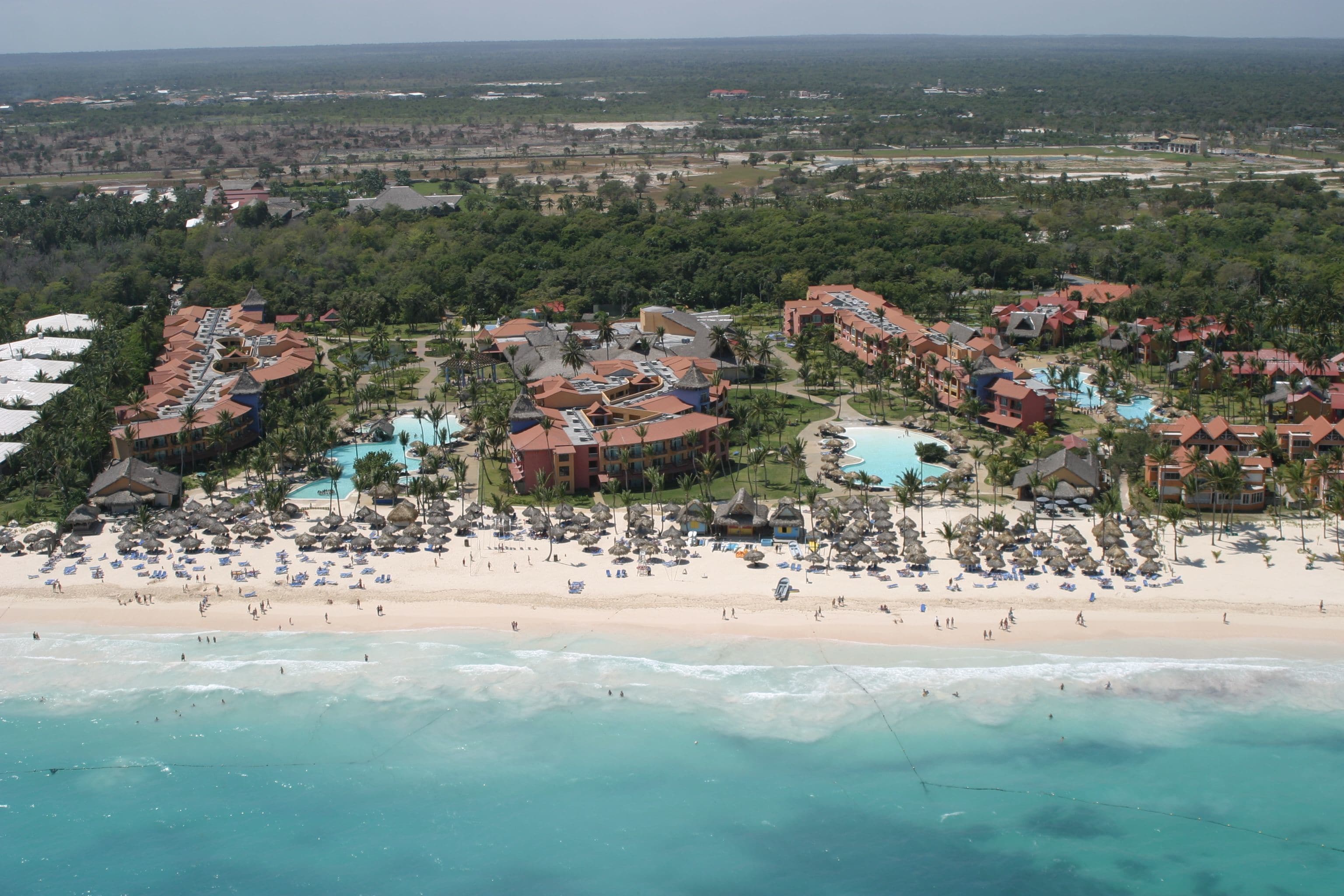 A resort with multiple buildings, a beach, and a pool area.