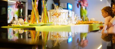 A bar area with a reflective surface, glassware, and colorful straws.
