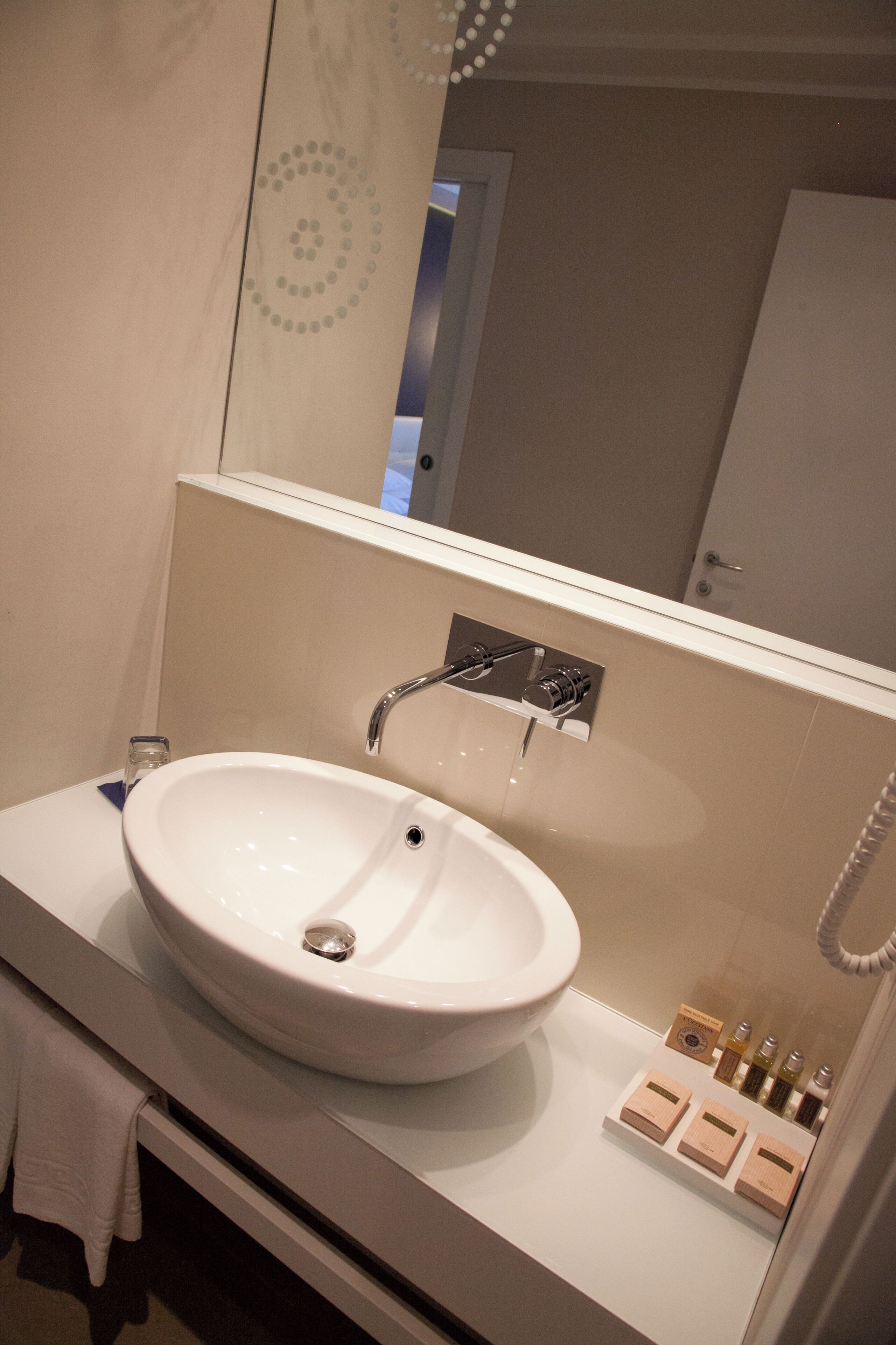 Une salle de bain avec un lavabo blanc, un miroir et une douche.