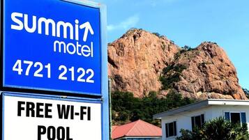 A sign for Summit Motel with a phone number and mentions free Wi-Fi and a pool.