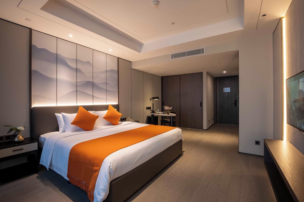 Een moderne hotelkamer met een groot bed, een bureau en een zithoek.