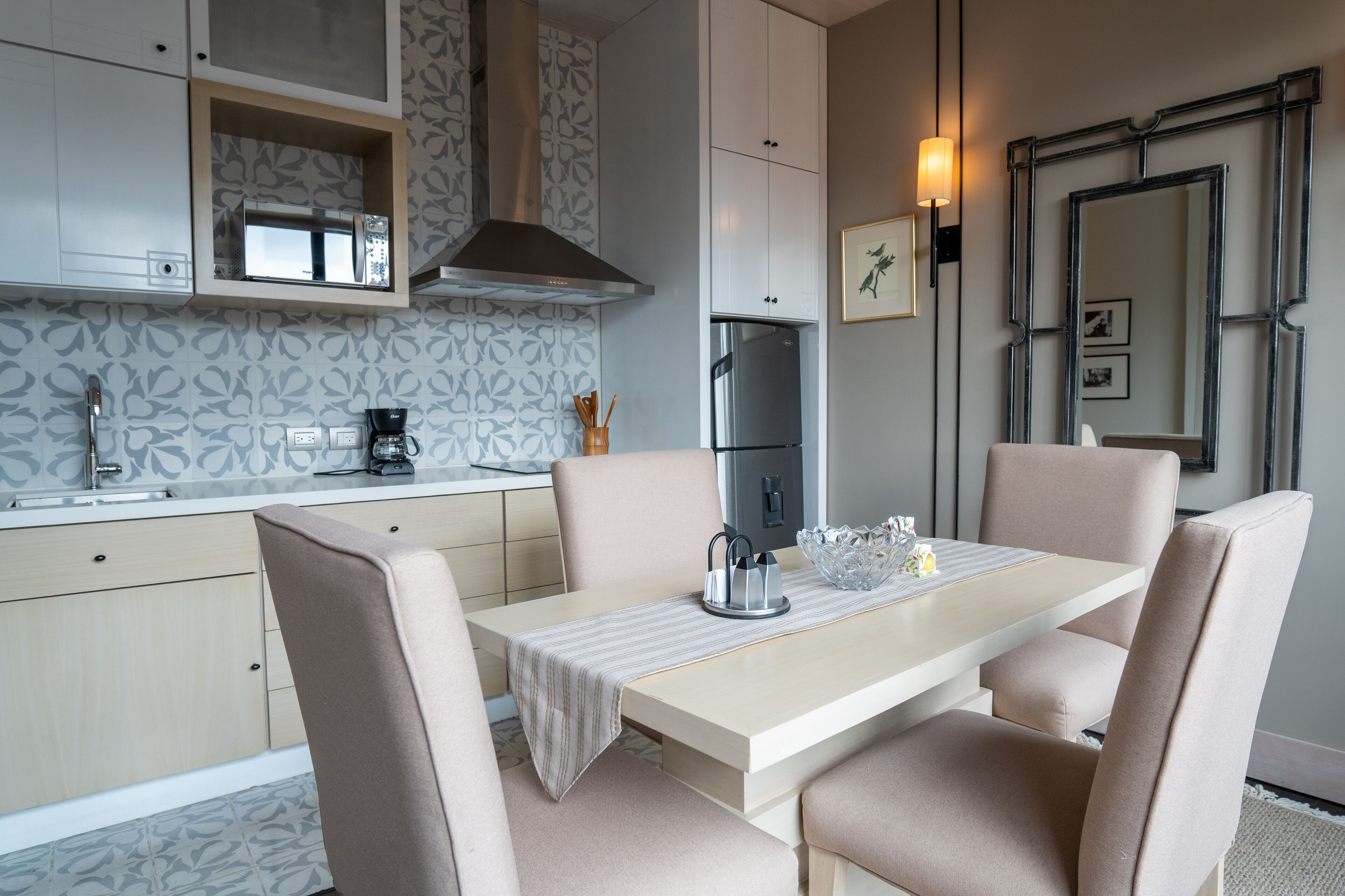 A modern kitchen with a dining area, featuring a microwave, stove, and refrigerator.