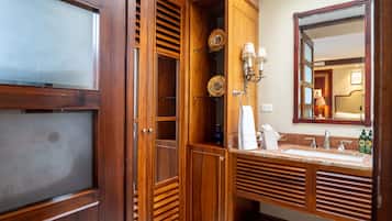 Un tocador de madera con un espejo grande, un lavabo y un perchero para toallas.