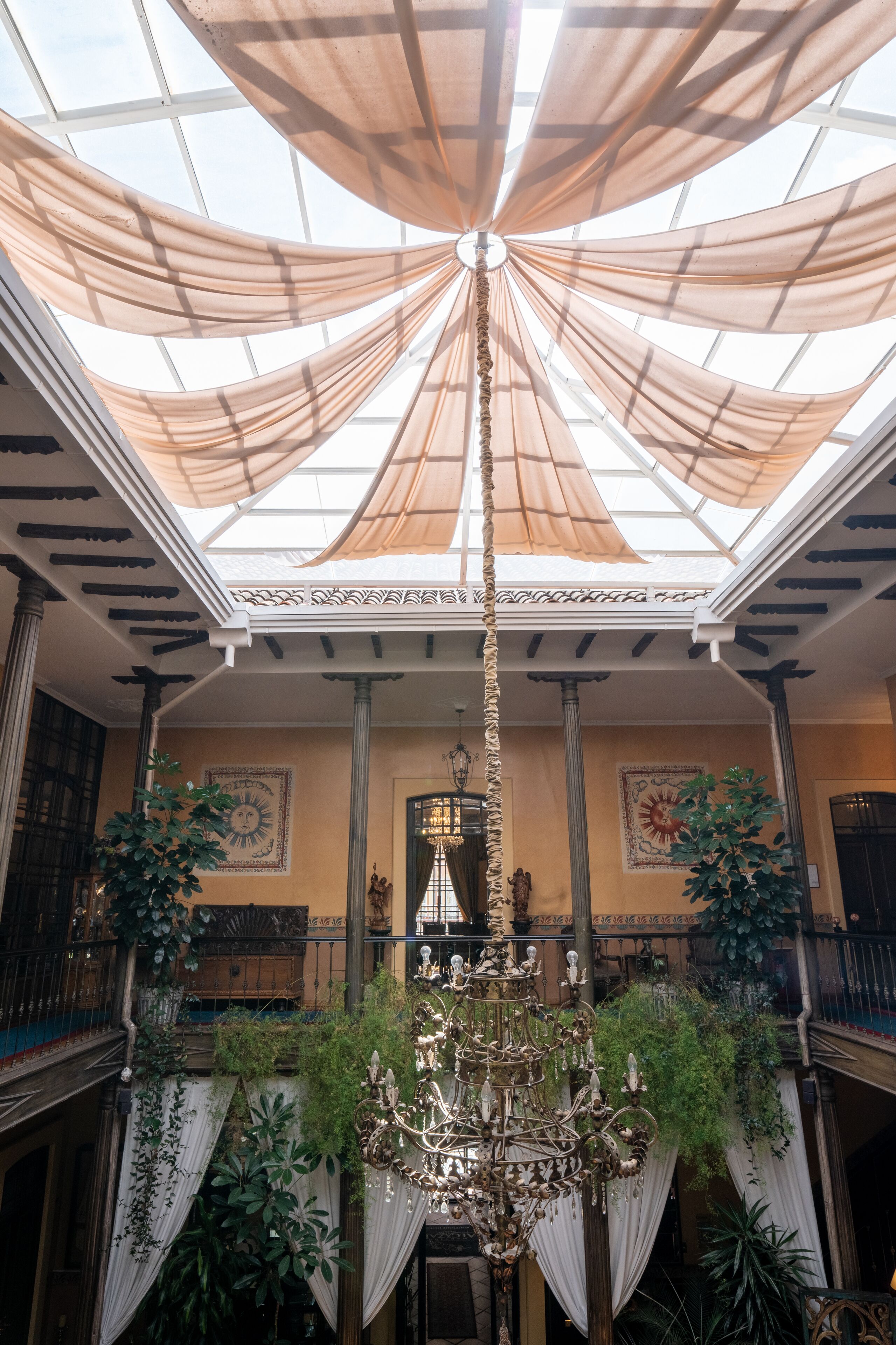 A grand hall with a high ceiling, a chandelier, and decorative columns.