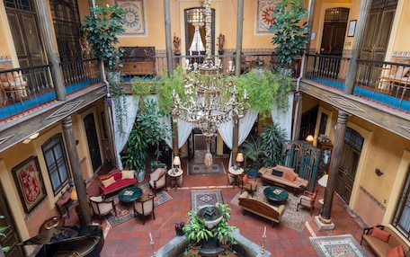 A spacious courtyard with a fountain, seating areas, and a chandelier.
