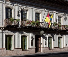 A building with ornate architectural details, multiple windows, and balconies with flower boxes.