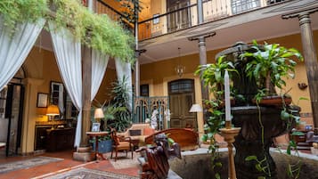 A spacious lobby with a fountain, seating area, and a staircase leading to an upper level.