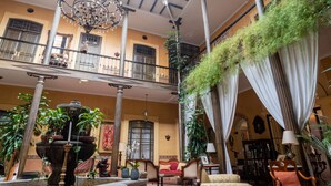 A spacious atrium with a fountain, multiple seating areas, and a balcony with greenery.