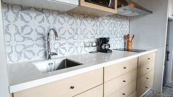 A modern kitchen with a double sink, a coffee maker, and a microwave.