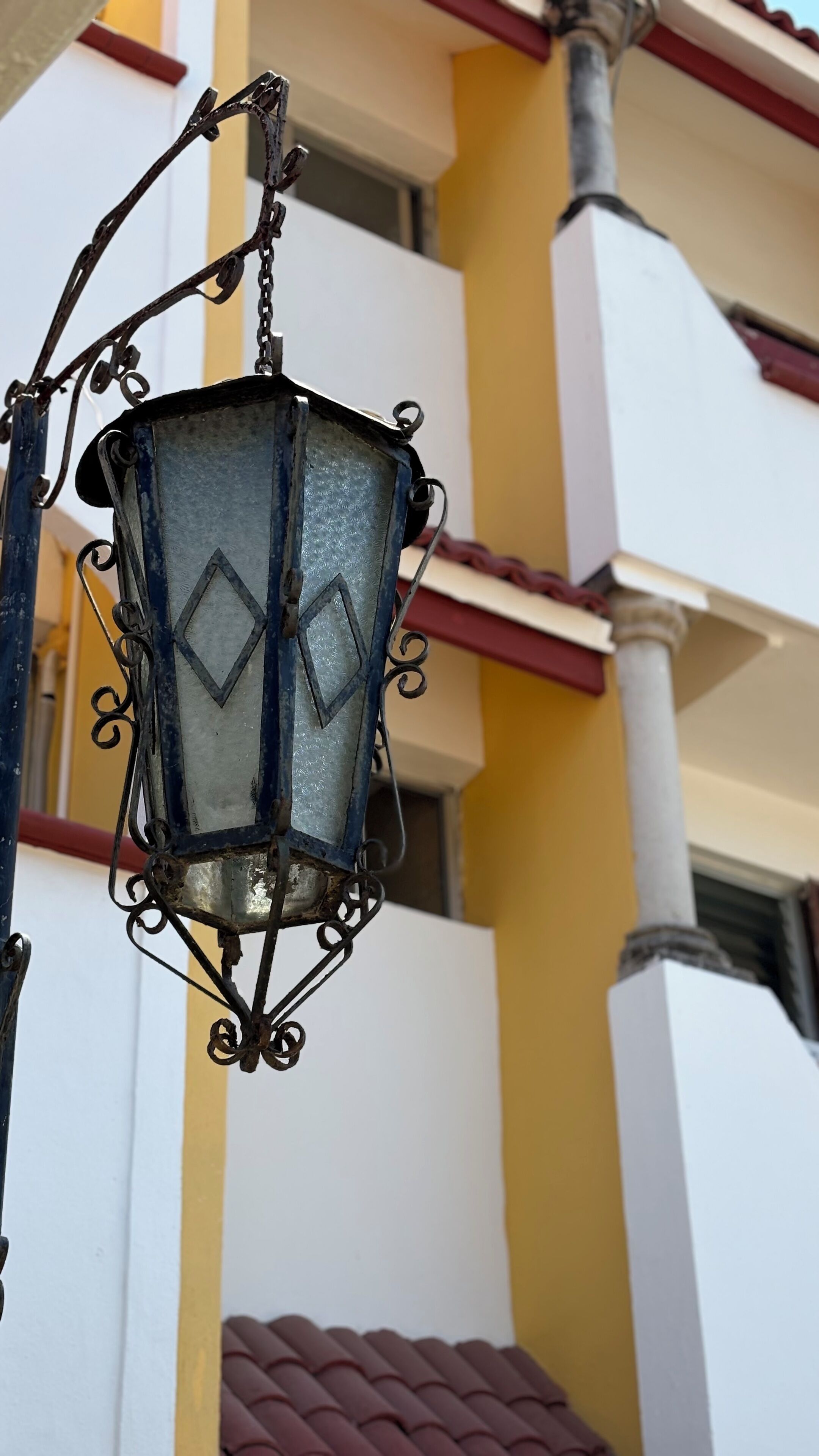 Een hanglamp met een diamantpatroon, bevestigd aan een metalen fitting.