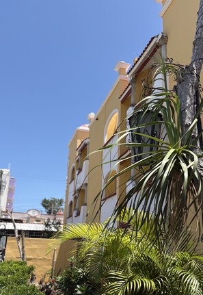 Un edificio amarillo con balcones y un cielo azul despejado.