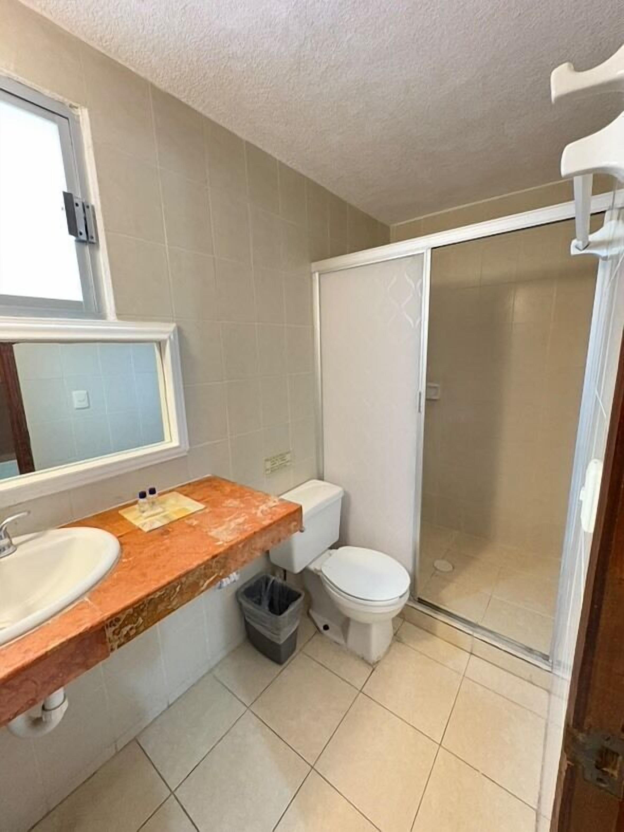 Un baño con lavabo, inodoro y ducha.