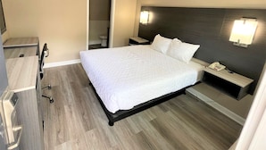 Ein Hotelzimmer mit Bett, Nachttisch und Spiegel.