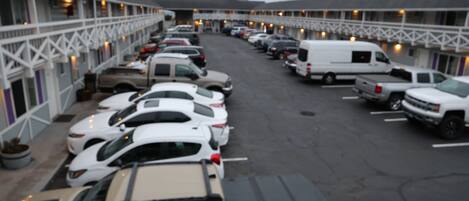 Un motel con varios espacios de estacionamiento y una fila de habitaciones con balcones.