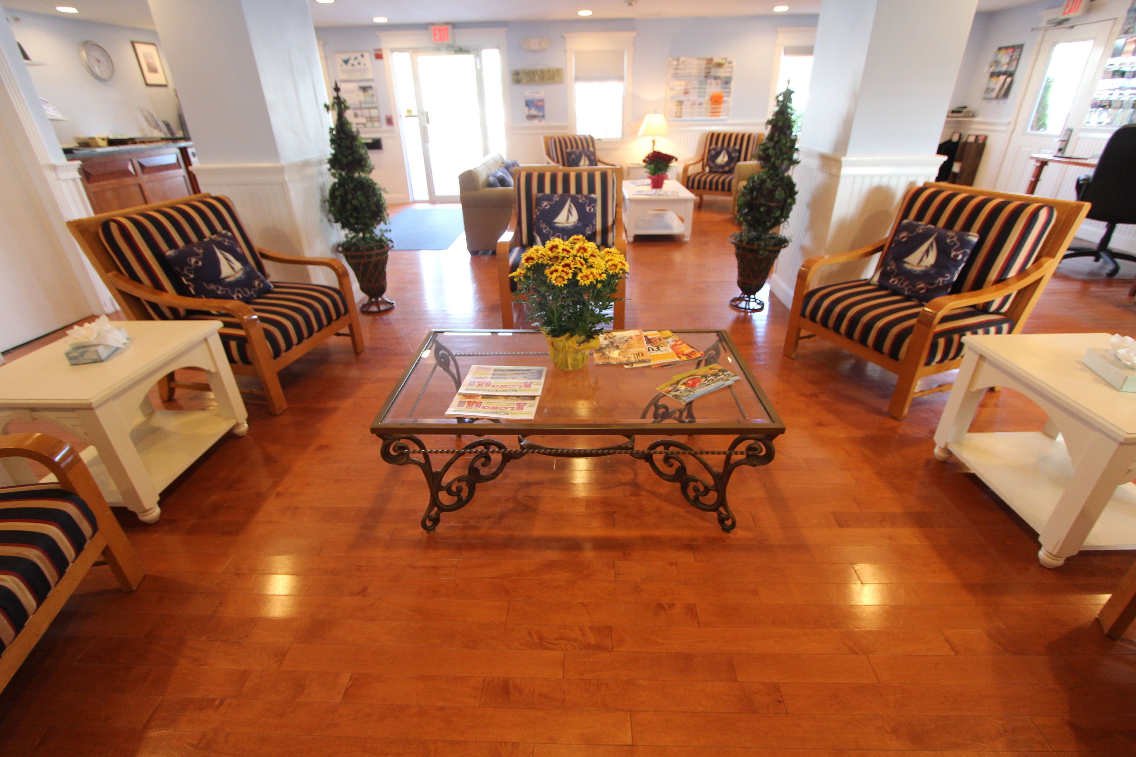 A spacious lobby with striped armchairs, a central coffee table, and a Christmas tree.