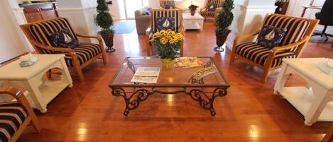A spacious lobby with striped armchairs, a central coffee table, and a Christmas tree.
