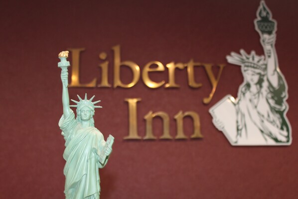 A statue of the Statue of Liberty in front of a sign that reads "Liberty Inn".