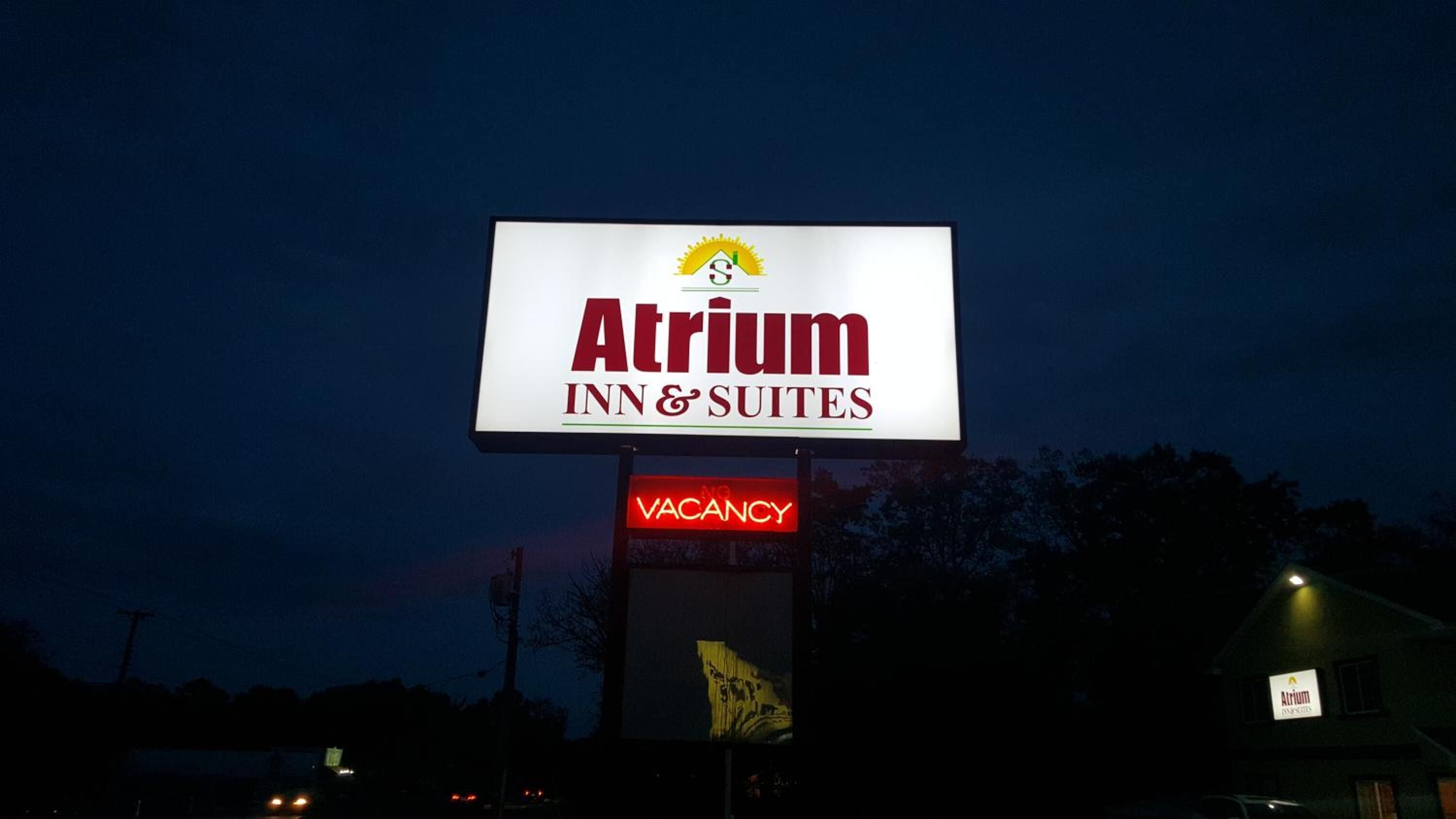 Señal para el Atrium Inn & Suites con aviso de habitaciones disponibles.