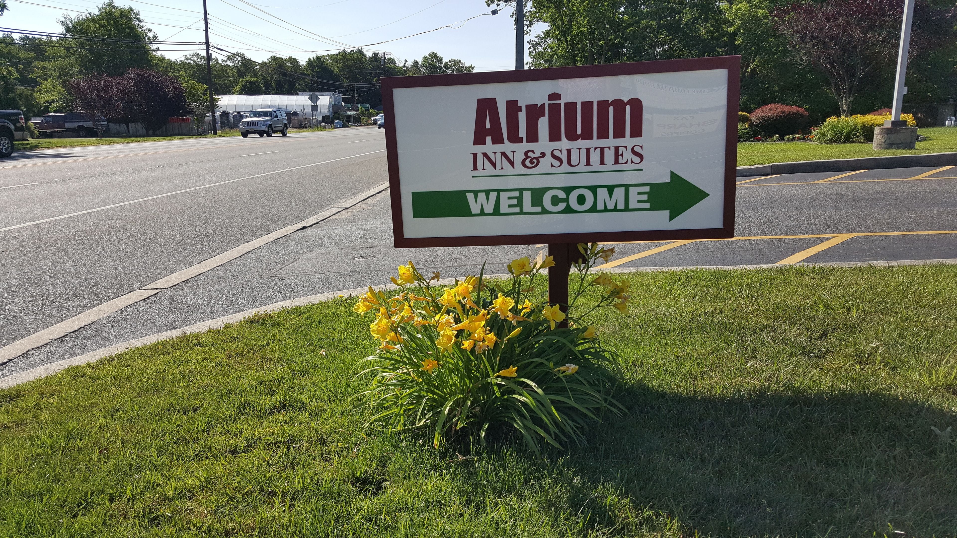 Señal para Atrium Inn & Suites, con una flecha de bienvenida.