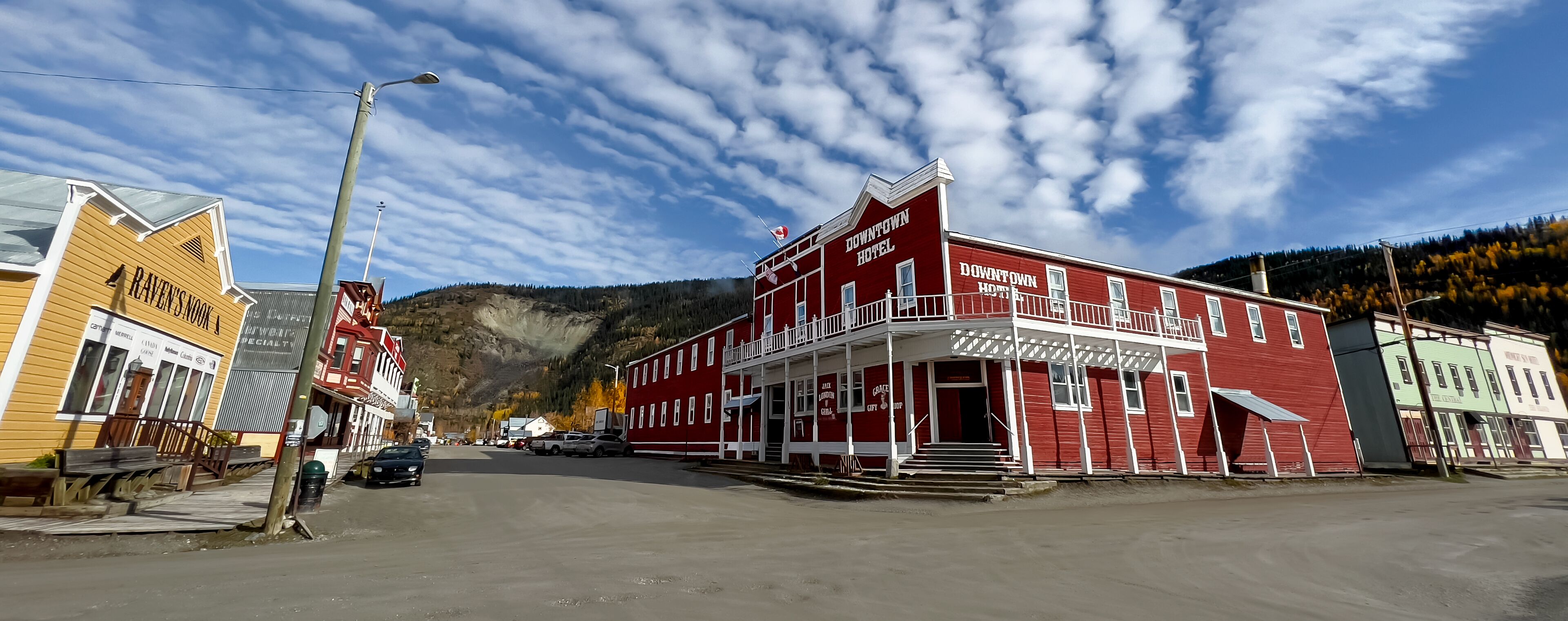 A red building with a balcony and a sign that reads "Downtown Hotel."
