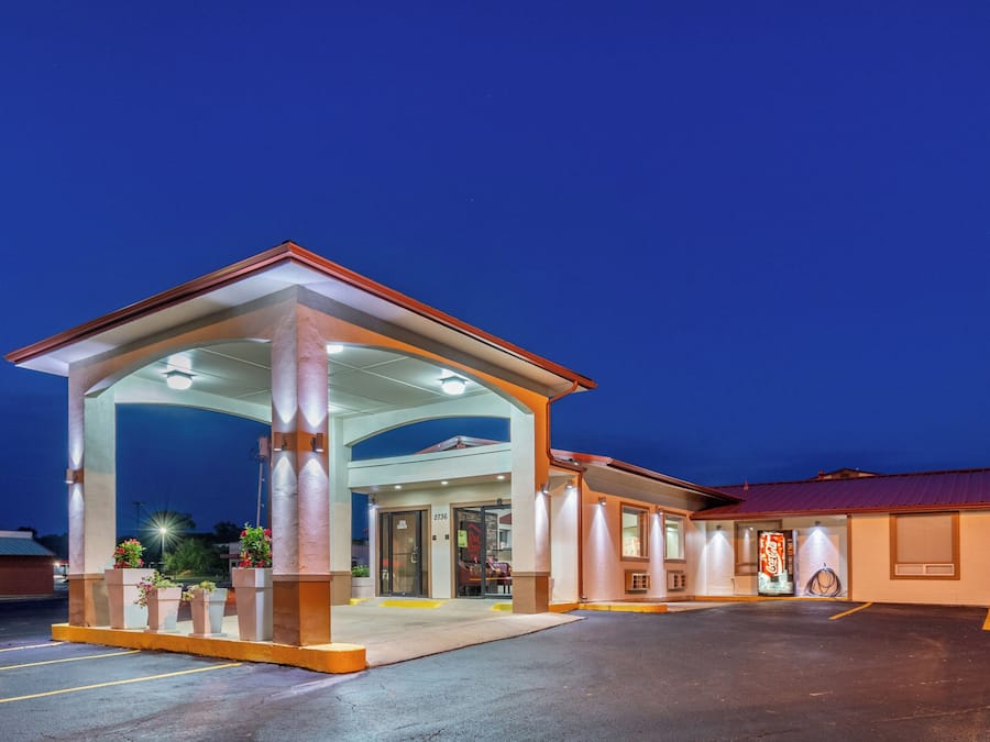 L’entrée d’un hôtel, avec un espace d’attente abrité et un distributeur automatique de Coca-Cola.