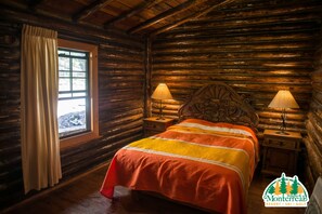 A log cabin room with a bed, two bedside lamps, a window with curtains, and a wooden headboard. - Bosques De Monterreal (Arteaga)