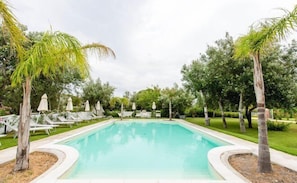 Una piscina techada, una piscina al aire libre, sombrillas
