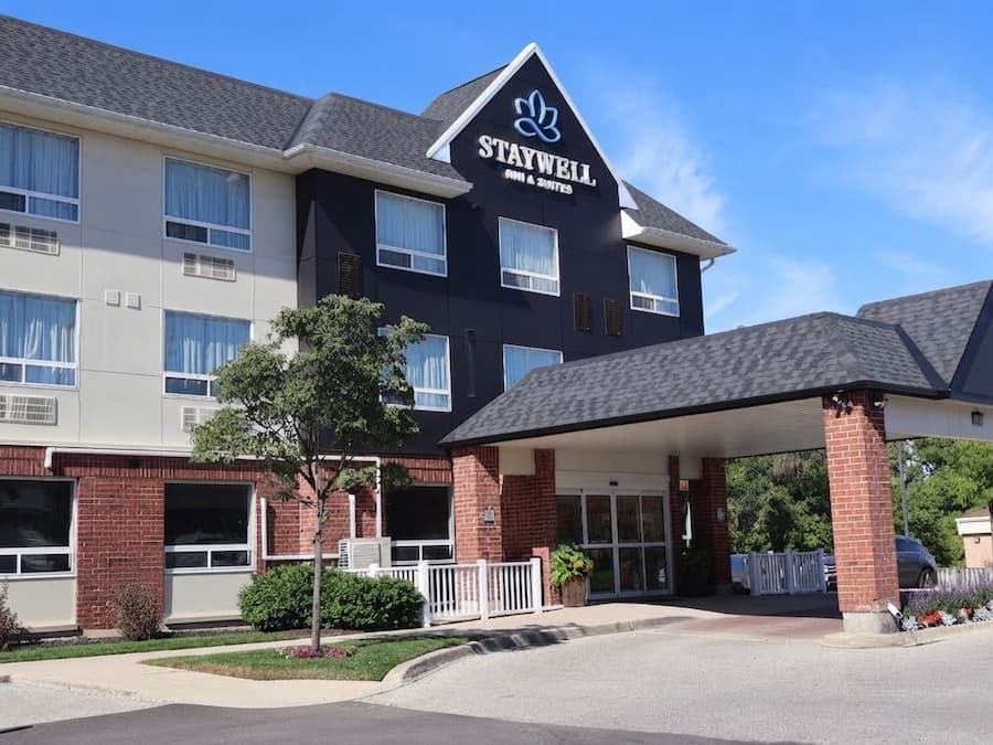 A Staywell hotel with a covered entrance, multiple windows, and a brick facade.