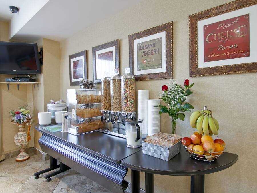 A breakfast bar with various food items, a television, and framed pictures on the wall.